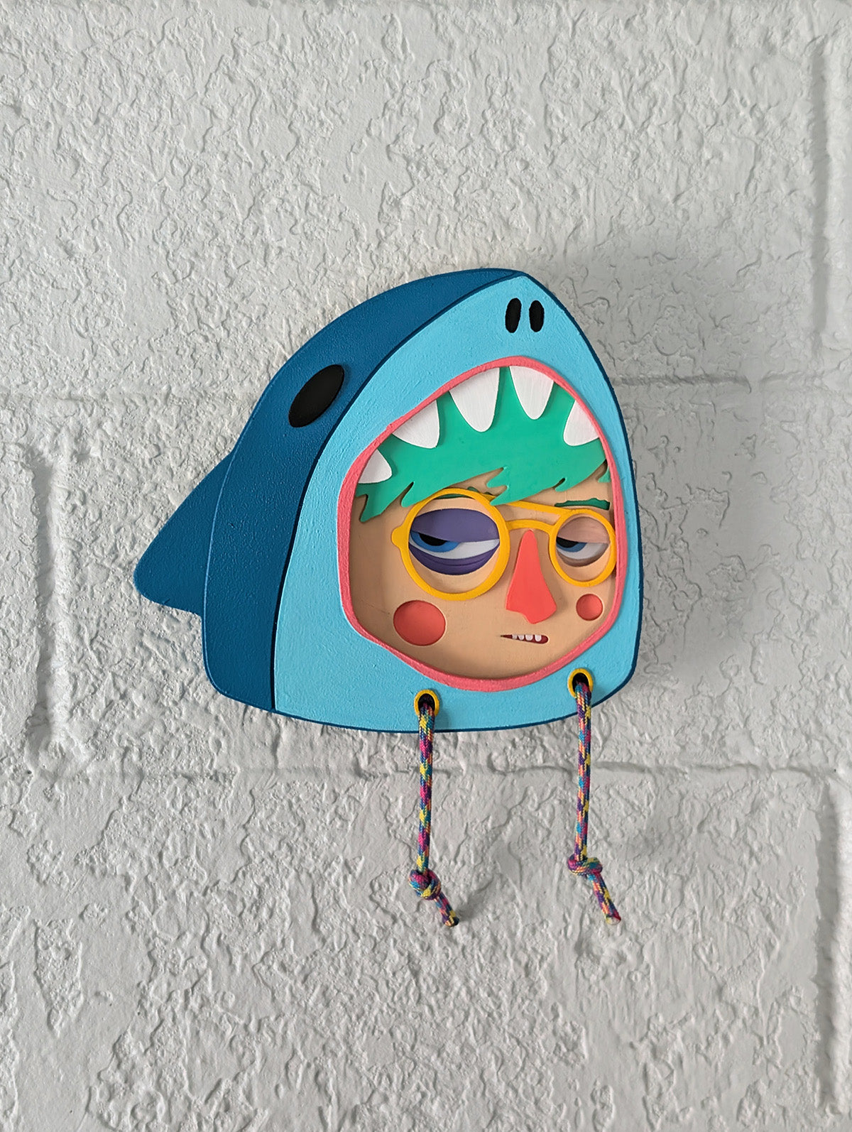 Teal shark hoodie frame used for a multi-layered character on a brick wall