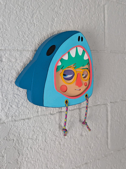 Teal shark hoodie frame used for a multi-layered character on a brick wall
