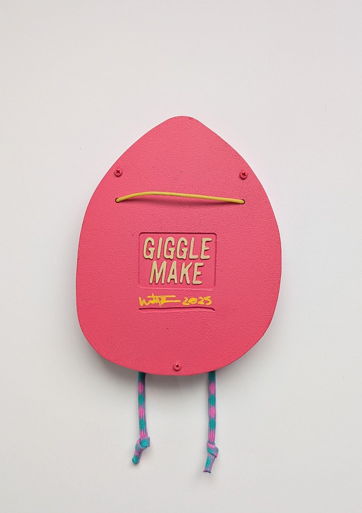 A rear view of a magenta in color hoodie style wall sculpture that depicts hanging hardware shown with a white background.